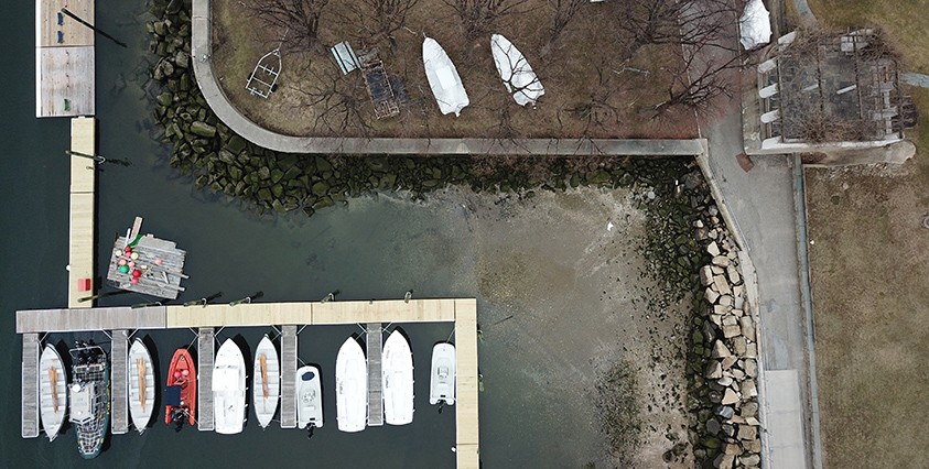 aerial view of boats at a dock on the water and green land