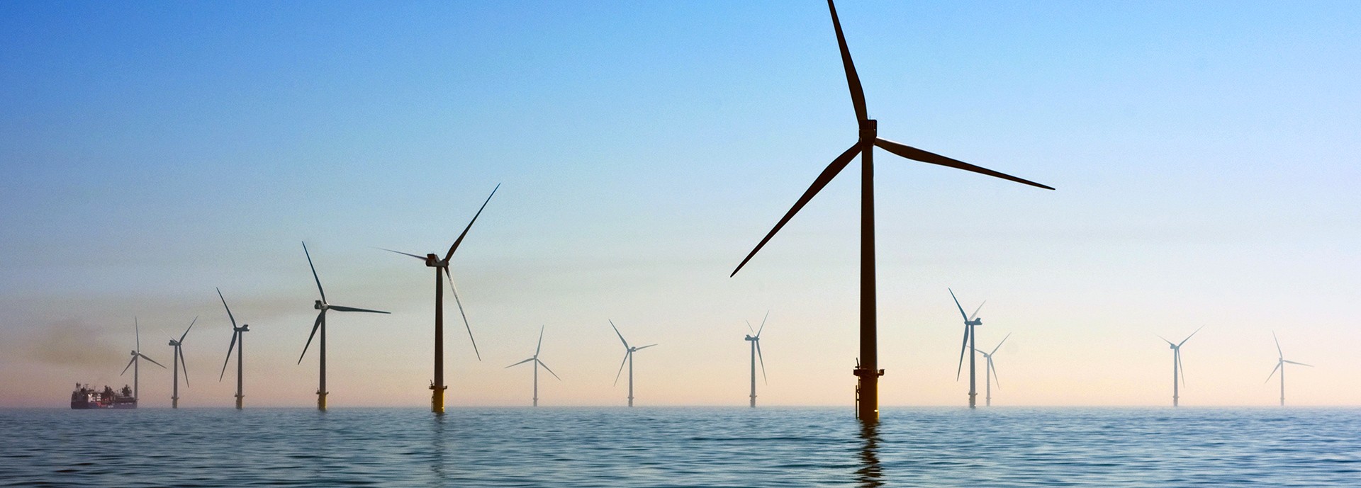 wind turbines in water at sun set / dusk