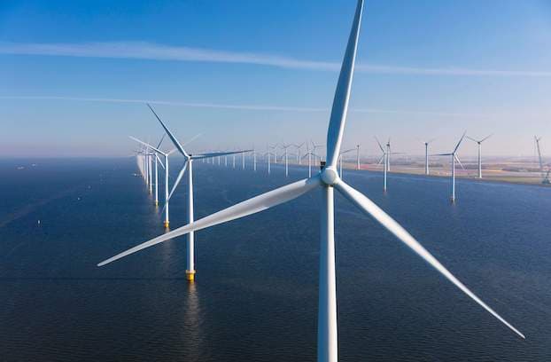 A panoramic view of a wind farm, with multiple wind turbines in the background