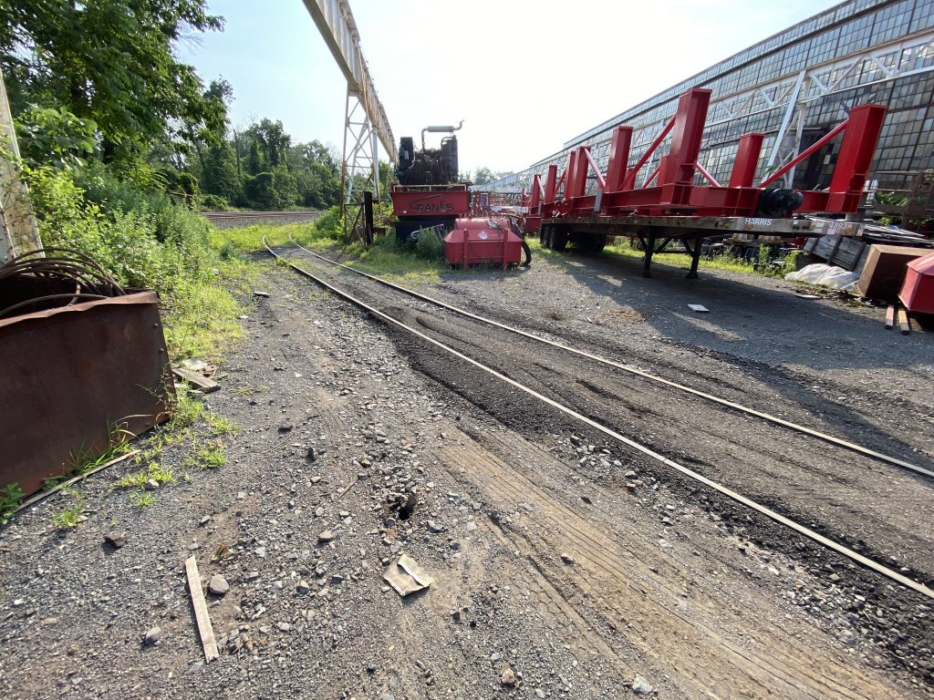 Equipment and steel structures on job site near train tracks