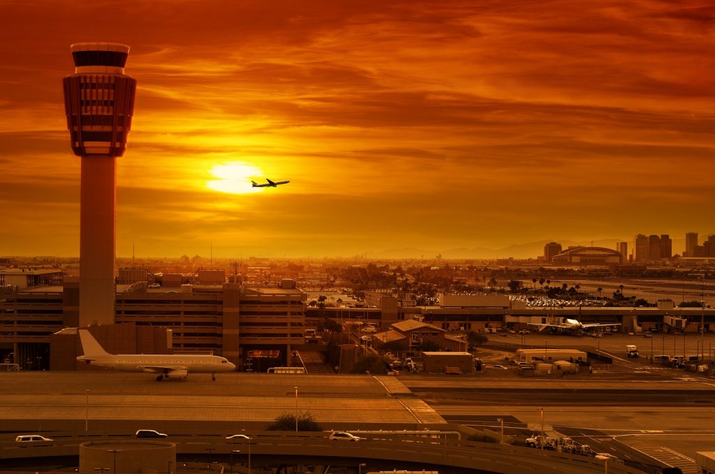 airport control tower and airplane taking off at sunset