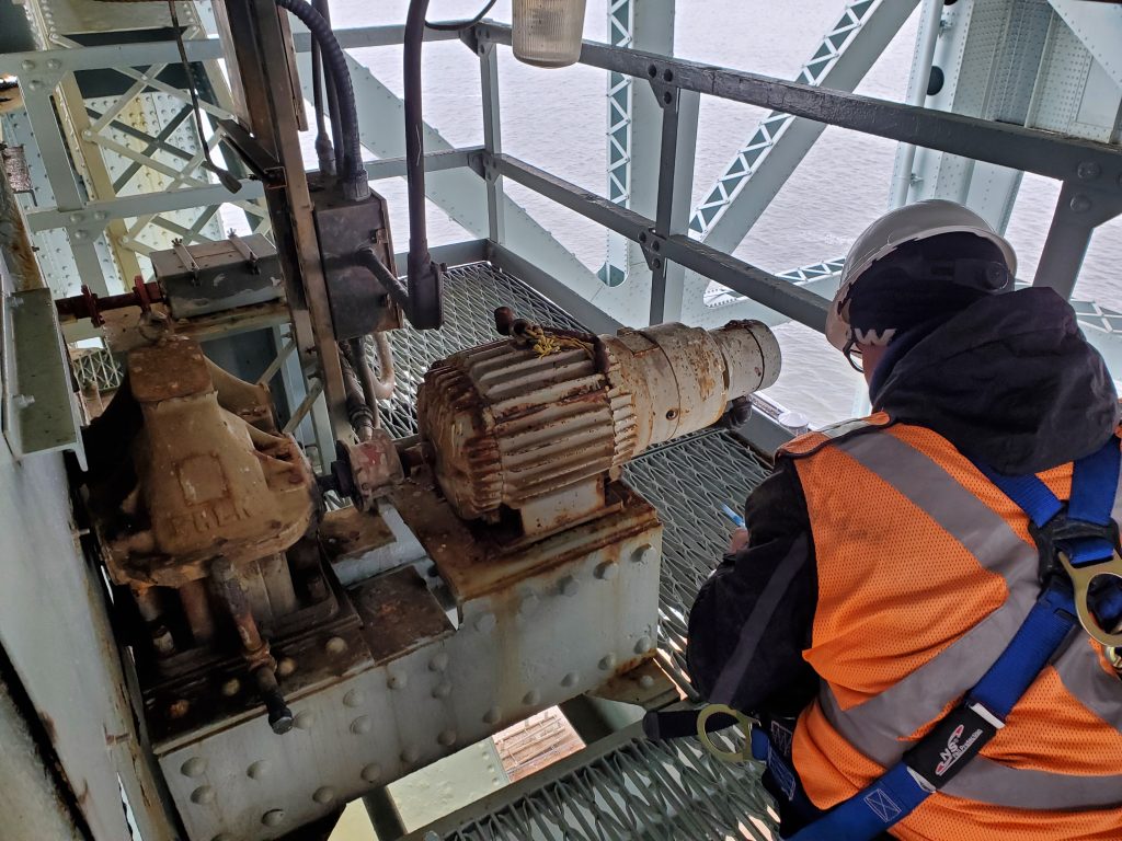 worker inspecting metal landing platform of bridge
