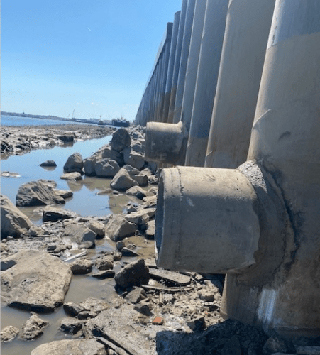closeup of drainage wall pipes on water shoreline