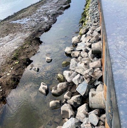 bulkhead from above with rocky shoreline and water