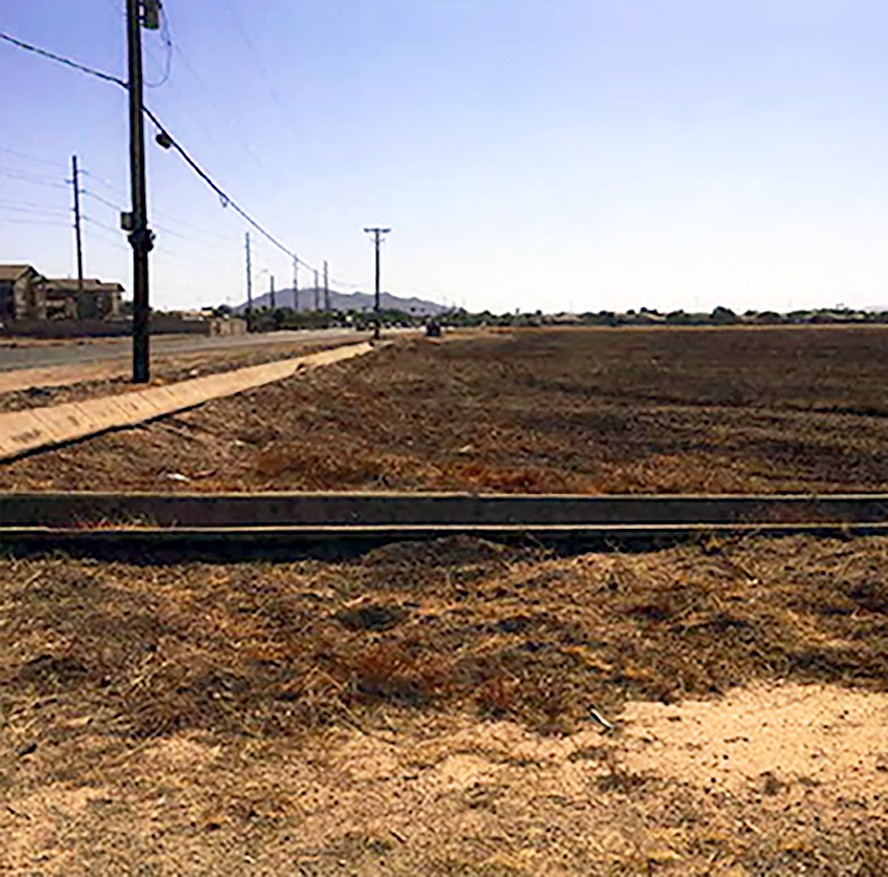 train tracks on dusty land with open area and blue sky