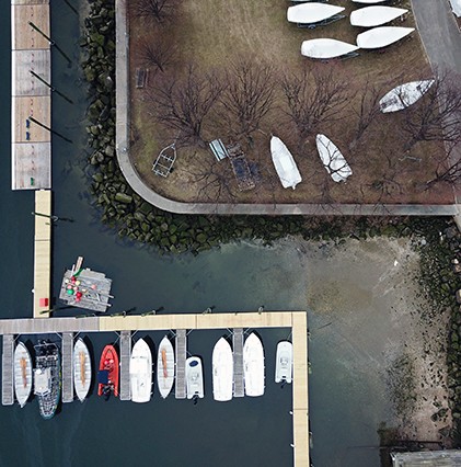 aerial shot of boats and pier on water at merchant marine academy