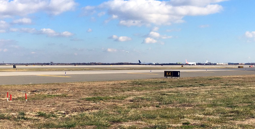 distant view of jfk runway with planes at k4 extension with a k4 sign