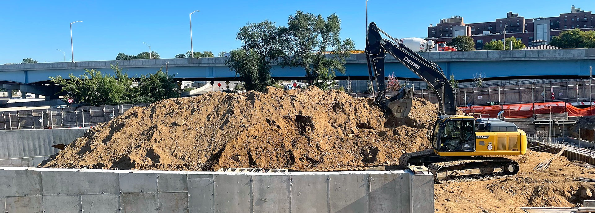 pile of dirt with tractor equipment in concrete wall