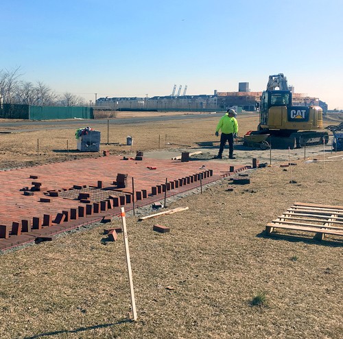 worker on job site paying brick pathway in bayonne