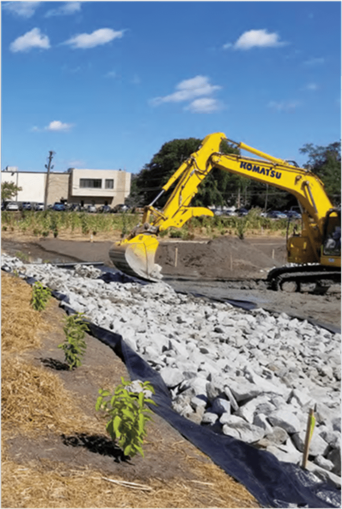 excavator moving stones to a newly landscaped area