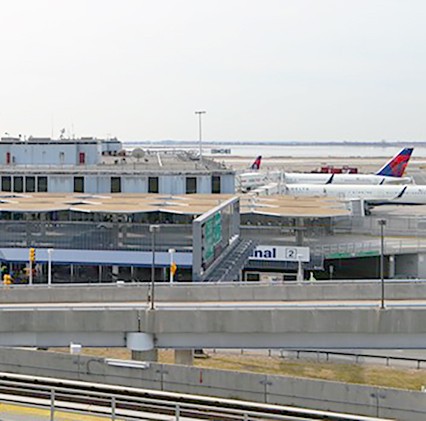 view of jfk airport terminal with plan on right on a cloudy day