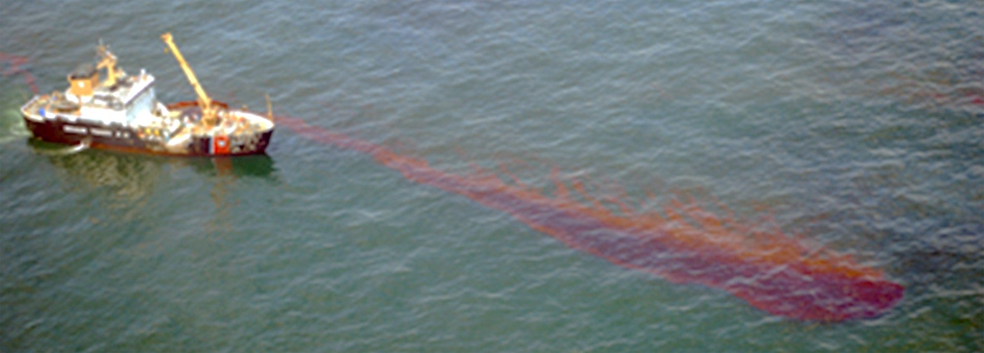 aerial view of boat by oil slick in water