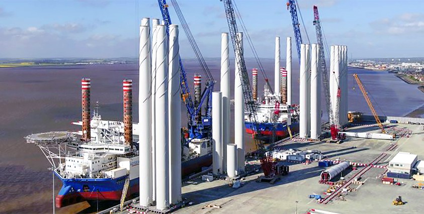 offshore wind facility infrastructure on waterfront with tall structures and boat