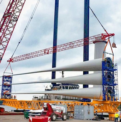view of wind turbine blades comes off boat by crane
