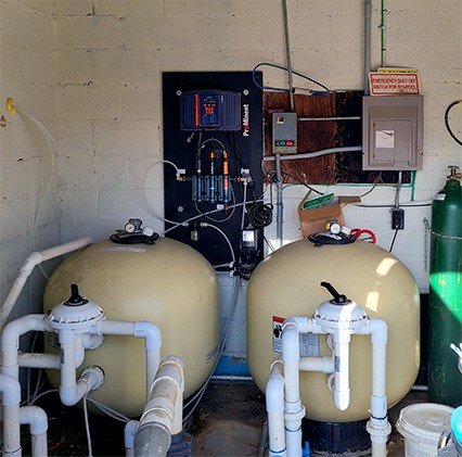 2 beige tanks with plastic piping in utility area
