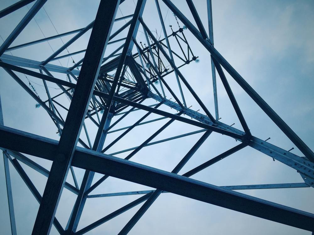 view of electrical tower looking toward sky, with center to the side